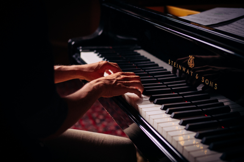 Photo by Claude Gabriel on Unsplash: https://unsplash.com/photos/person-playing-black-upright-piano-yvEVMyTzMO4