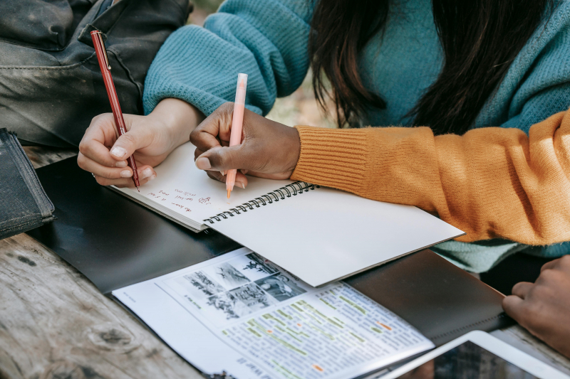 Photo by Charlotte May: https://www.pexels.com/photo/crop-unrecognizable-diverse-schoolgirls-taking-notes-in-copybook-in-park-5965857/