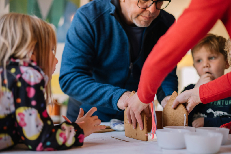 Photo by Phillip Goldsberry on Unsplash: https://unsplash.com/photos/two-person-making-gingerbread-house-and-three-children-watching-them-lP3Fue7Xxxk