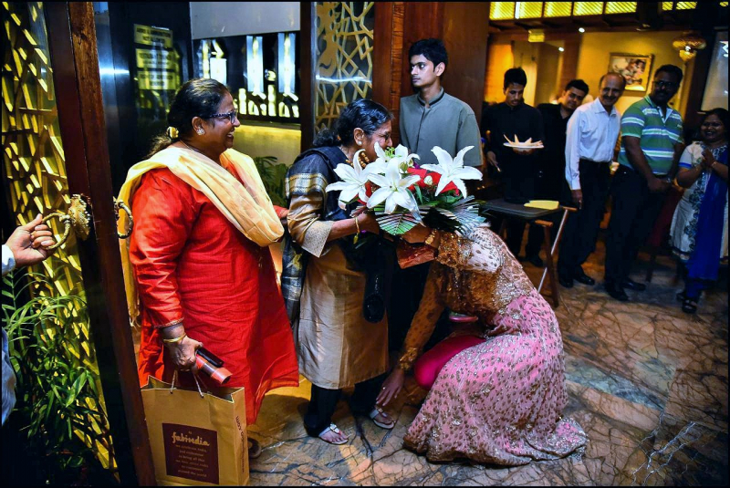 Anca Verma touching feet of Veena Verma on 1st September 2016, the 75th birthday of Veena Verma. Photo on Wikimedia Commons