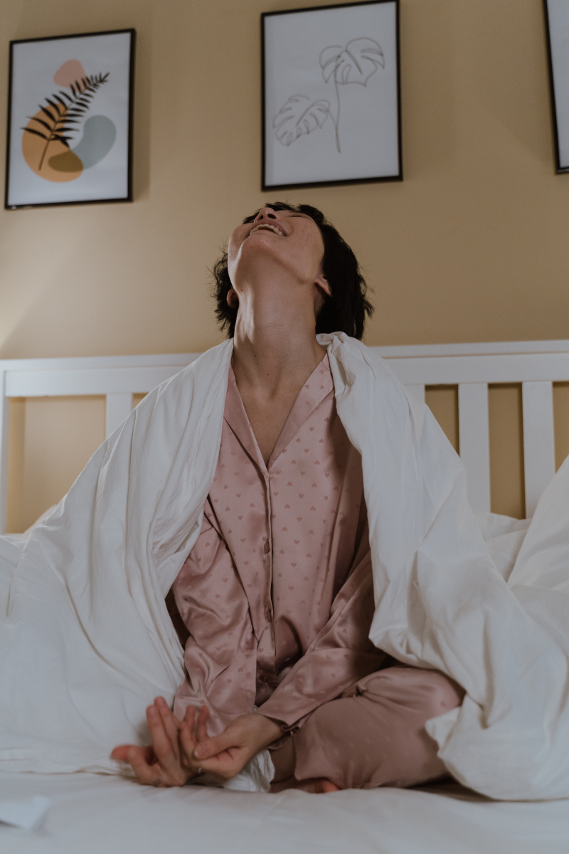 Photo by cottonbro studio: https://www.pexels.com/photo/laughing-woman-sitting-on-bed-in-pink-pajamas-6716588/