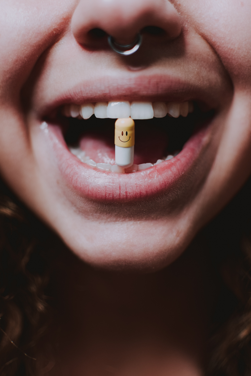 Photo by lil artsy: https://www.pexels.com/photo/faceless-woman-with-pill-in-teeth-and-nose-piercing-6228273/