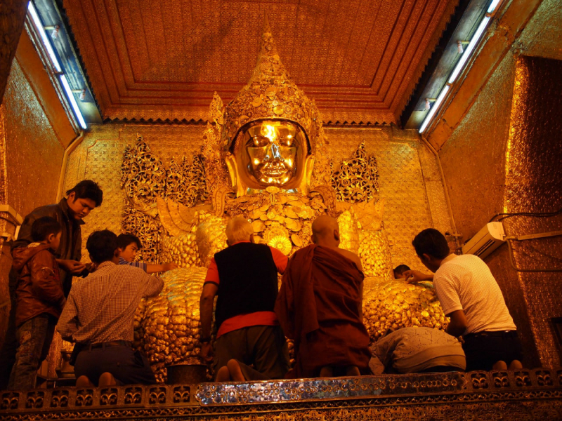 Photo on Wikimedia Commons (https://commons.wikimedia.org/wiki/File:Prayers_and_gold_leaf_being_applied_by_devotees_Buddhist_culture_religion_rites_rituals_sights.jpg)