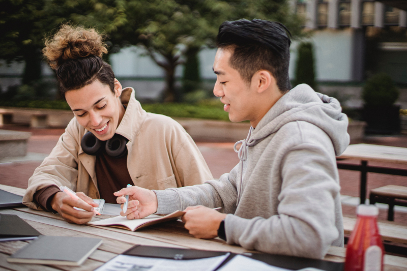 Photo by Armin  Rimoldi: https://www.pexels.com/photo/happy-diverse-male-students-working-on-home-assignment-in-park-5553938/